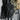 Small tactical one-strap assault pack in black with textured front straps and zippers