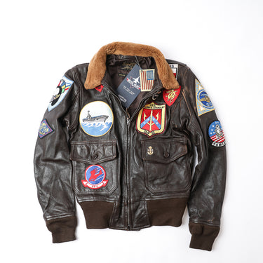 Brown leather flight jacket with tan shearling collar and embroidered patches