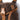 Brown kit bag corner with logo patch, tan webbing, and buckle strap