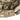 Camo bucket hat brim close-up with strap buckle and small square logo patch.