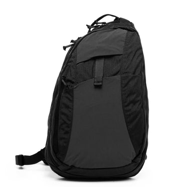 Black sling backpack with top handle, front pocket panel, and adjustable strap