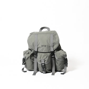Mini backpack in light gray fabric with front pockets, webbing straps, and top handle