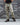 Desert camo combat pants worn with lace-up boots, full-length side view