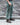 Teal-green cargo pants showing side cargo pocket and tapered leg cuffs, worn with boots.