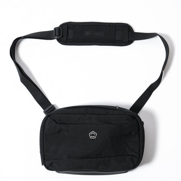 Horizontal sling pouch in black with zippered front pocket and adjustable shoulder strap