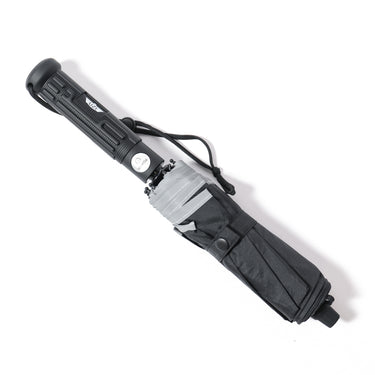 Folded tactical collapsible umbrella with dark gray fabric sleeve, black handle and strap