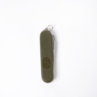 Olive drab folding pocket knife with textured handle and metal keyring lanyard