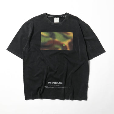 Black crewneck tee with rectangular woodland graphic and small logo text near hem