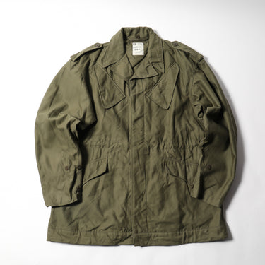 Olive drab combat parka with button front, flap chest pockets, and drawstring hem.