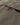 Olive jacket hem with woven multicolor brand tab and visible stitching.