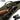 OD green rifle case with rifle, scope, and accessories stored in padded compartments