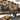 Rifle wall rack system with many firearms mounted on a tan slat wall
