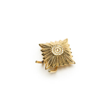 Gold metal star ranking cap badge with textured rays and circular center
