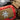 Red mini medical kit pouch with tan cross patch and gray hook label