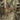 Multicam rucksack side detail with tan drawcord, webbing tabs, and buckles