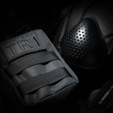 Tactical respirator with perforated face cover and black carry pouch with strap