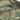 Camouflage duffel bag zipper with metal pulls and webbing trim detail.