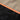 Softshell jacket seam with orange branded trim over textured gray-green fabric.