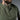Olive green henley shirt close-up with buttoned neckline and small chest logo