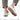 White sneakers with gum rubber sole and gray heel panel, worn with gray shorts