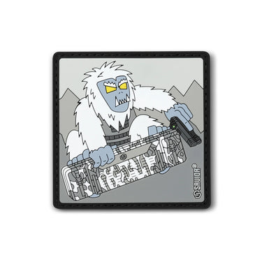 Square embroidered snowboard patch with white yeti holding striped guitar, dark border