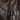 Dark brown leather jacket close-up of textured grain and snap closure strap