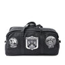Black duffel bag with top handle and front patches, including U.S.S. William H. Stanley