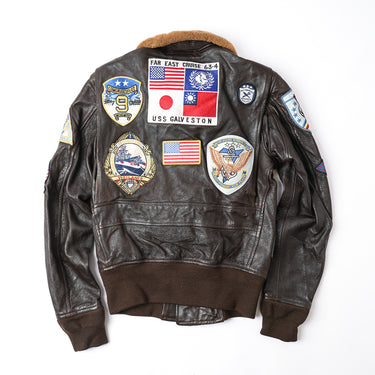Brown leather flight jacket with tan shearling collar and back mission patches