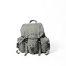 Mini backpack in light gray fabric with front pockets, webbing straps, and top handle