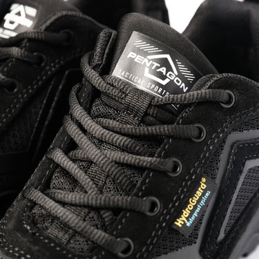 Black lace-up shoe close-up with Pentagon logo tongue and textured gray laces