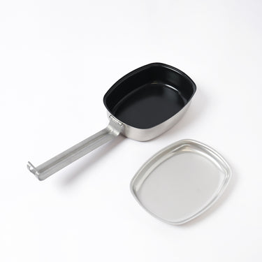 Stainless steel pot with black interior, lid, and long handle, silver finish