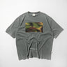 Grey crewneck tee with rectangular woodland graphic and small logo text near hem