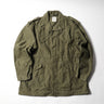 Olive drab combat parka with button front, flap chest pockets, and drawstring hem.