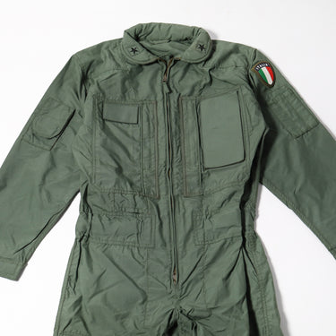 Sage green flight coverall close-up: zip front, chest pockets, and shoulder badge patch.