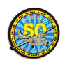 Round PVC patch with blue skyburst and yellow 50th anniversary over airplane graphic