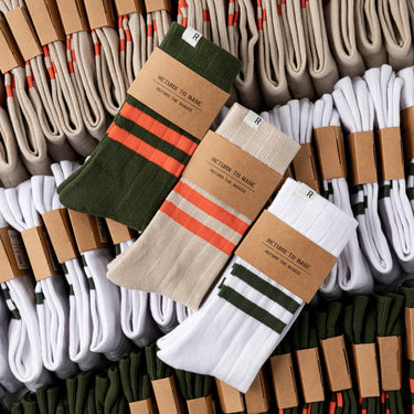 Assorted crew socks in white, olive, and tan with stripe bands