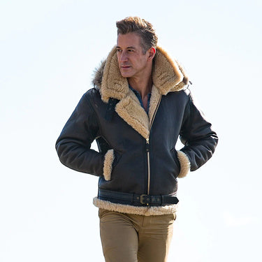 Sheepskin hooded leather jacket on model, shearling collar and cuffs, front zip, dark exterior