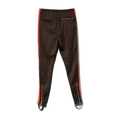 Brown track pants with red side stripes, elastic cuffs and zip pocket detail