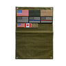 Olive green military patch panel with flag patches and metal grommets at corners