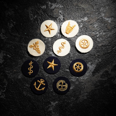 Set of embroidered officer career badges with gold star, anchor, shield and crest on round patches