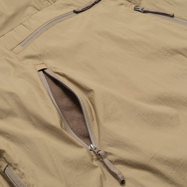 Olive drab smock jacket close-up of front zip and drawstring hem