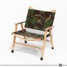 Foldable camping chair in green and brown woodland camo fabric with wooden armrests