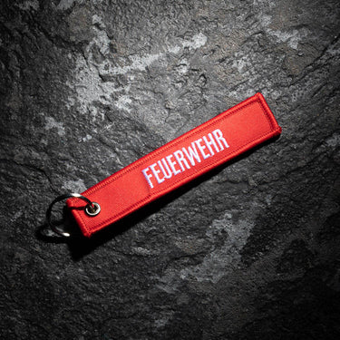 Red fabric key ring strap with embroidered FEUERWEHR lettering and metal ring