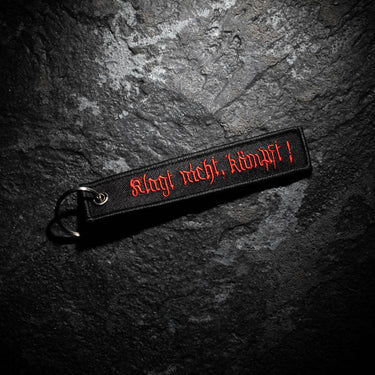 Black key ring strap with red embroidered lettering and silver metal ring
