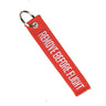 Red embroidered key ring with Remove Before Flight text and metal loop.